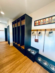 Custom mudroom with built-in storage lockers, cubbies, bench seating, and pet feeding station.