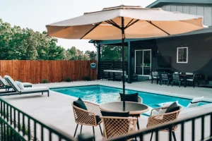 Poolside patio with outdoor dining area, umbrella seating, and covered entertaining space.
